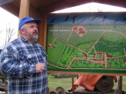 Joachim Brych, landwirtschaftlicher Leiter in Kuhhorst vor dem Lageplan von Kuhhorst bei der Exkursion